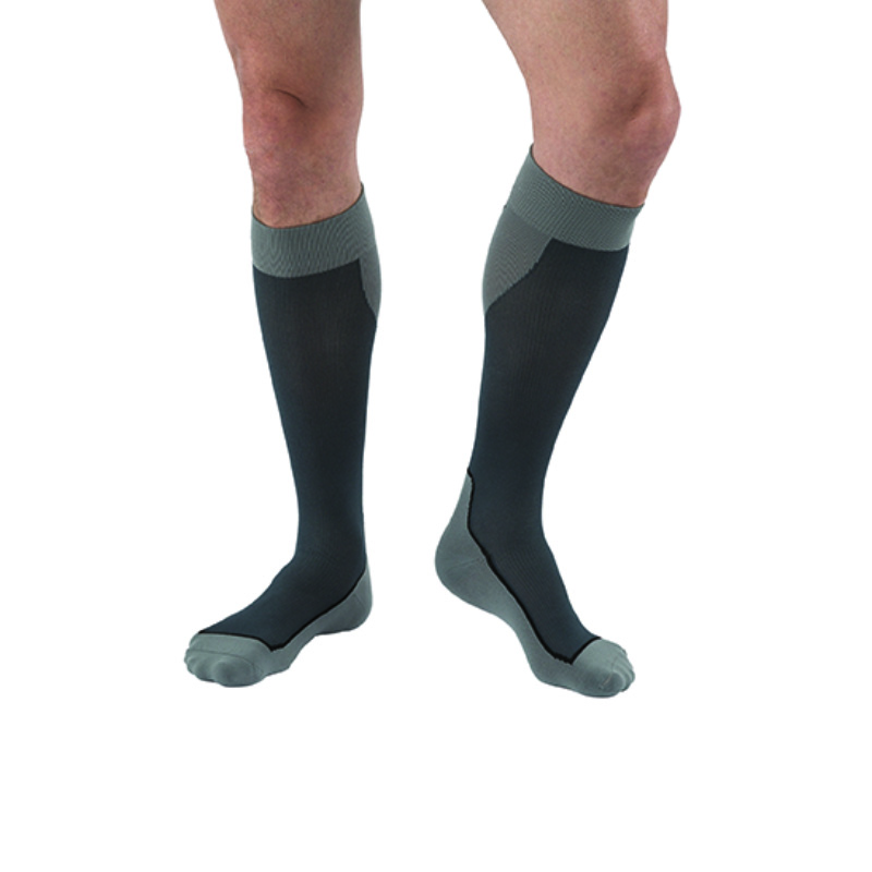 Ein Mann trägt Kompressionsstrümpfe beim Aufstehen Ein Mann trägt Kompressionsstrümpfe beim Aufstehen